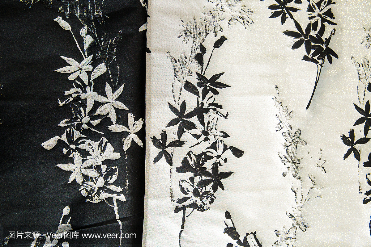 黑色和白色布料用于服装,带有花朵图案,布料背景
